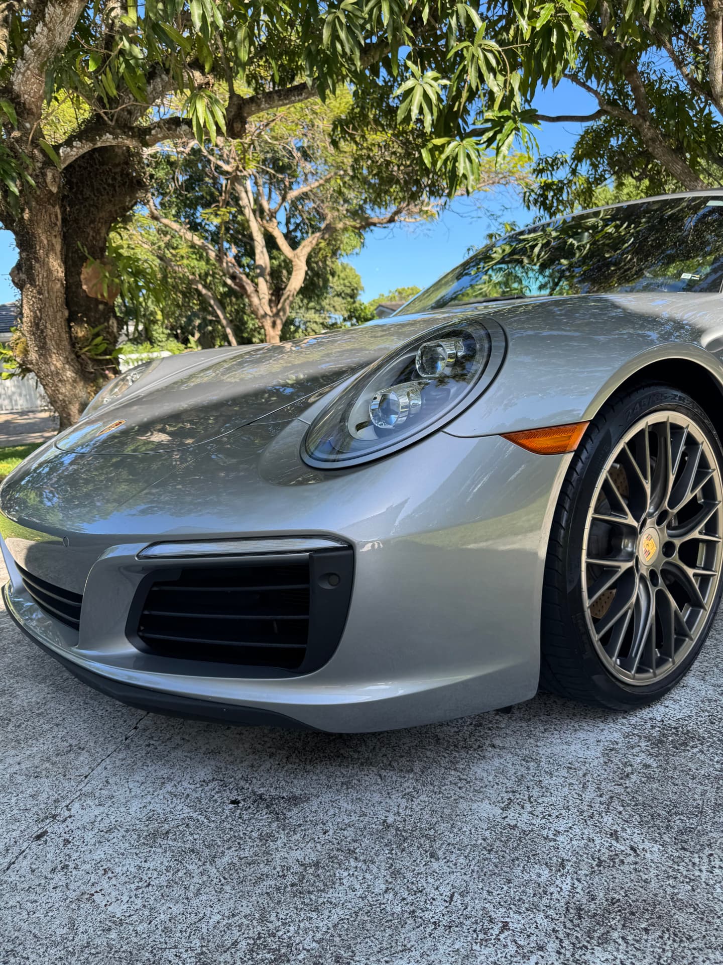 Silver sports car front wheel and bumper, dressed and glossy