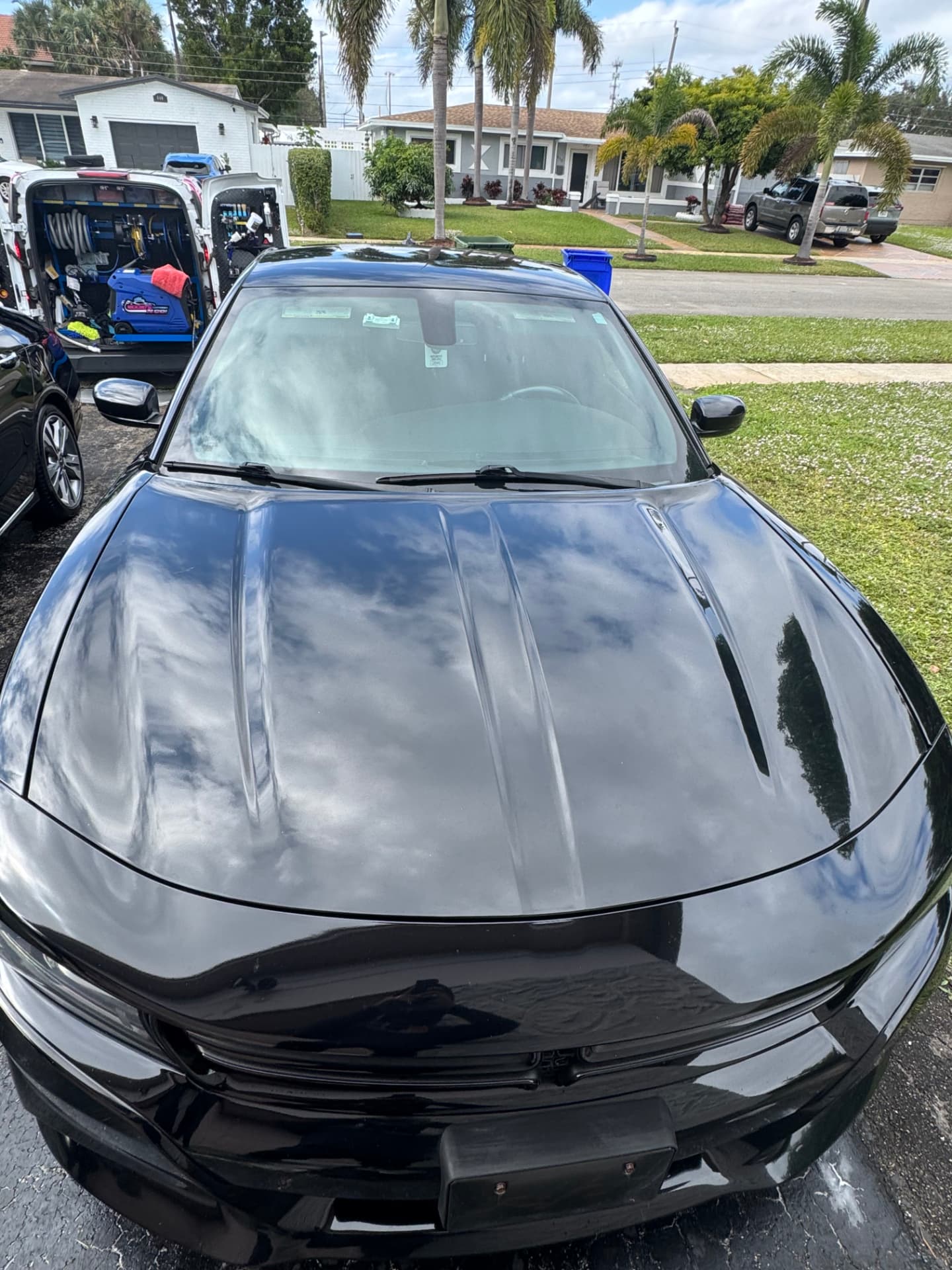 Black sedan hood and windshield, paint glossed to a mirror