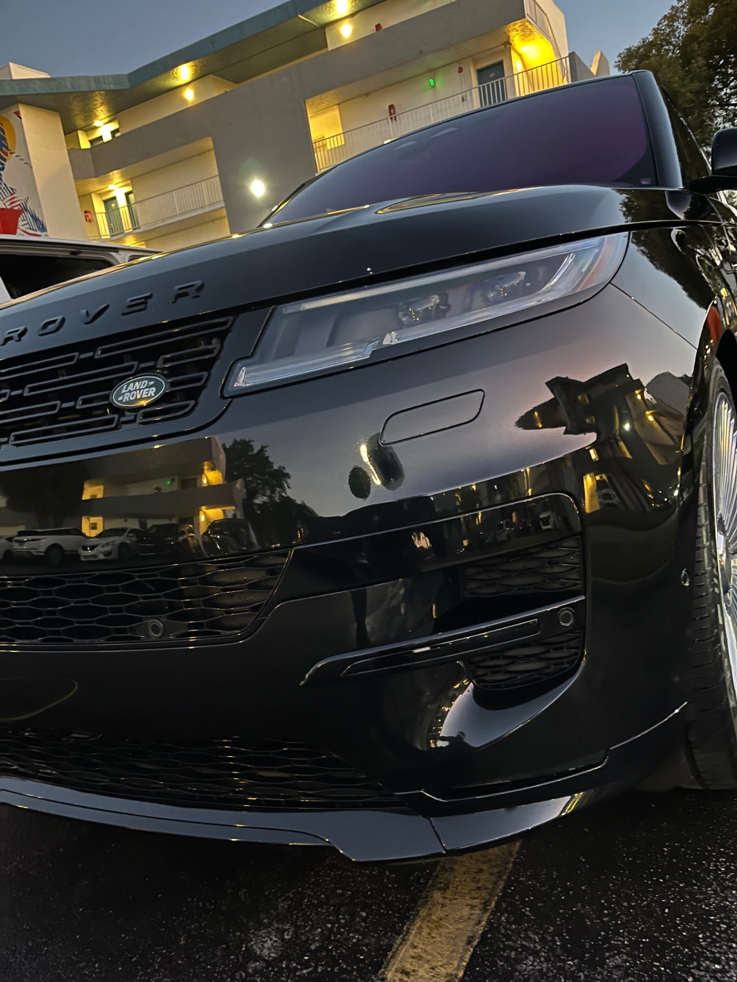 Black SUV front fascia, paint mirror-deep under garage light